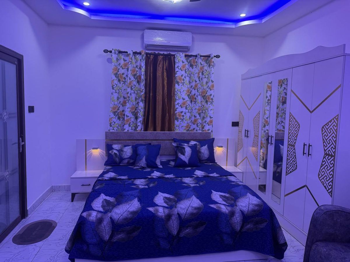 Bedroom with blue bedding and coloured ceiling lights